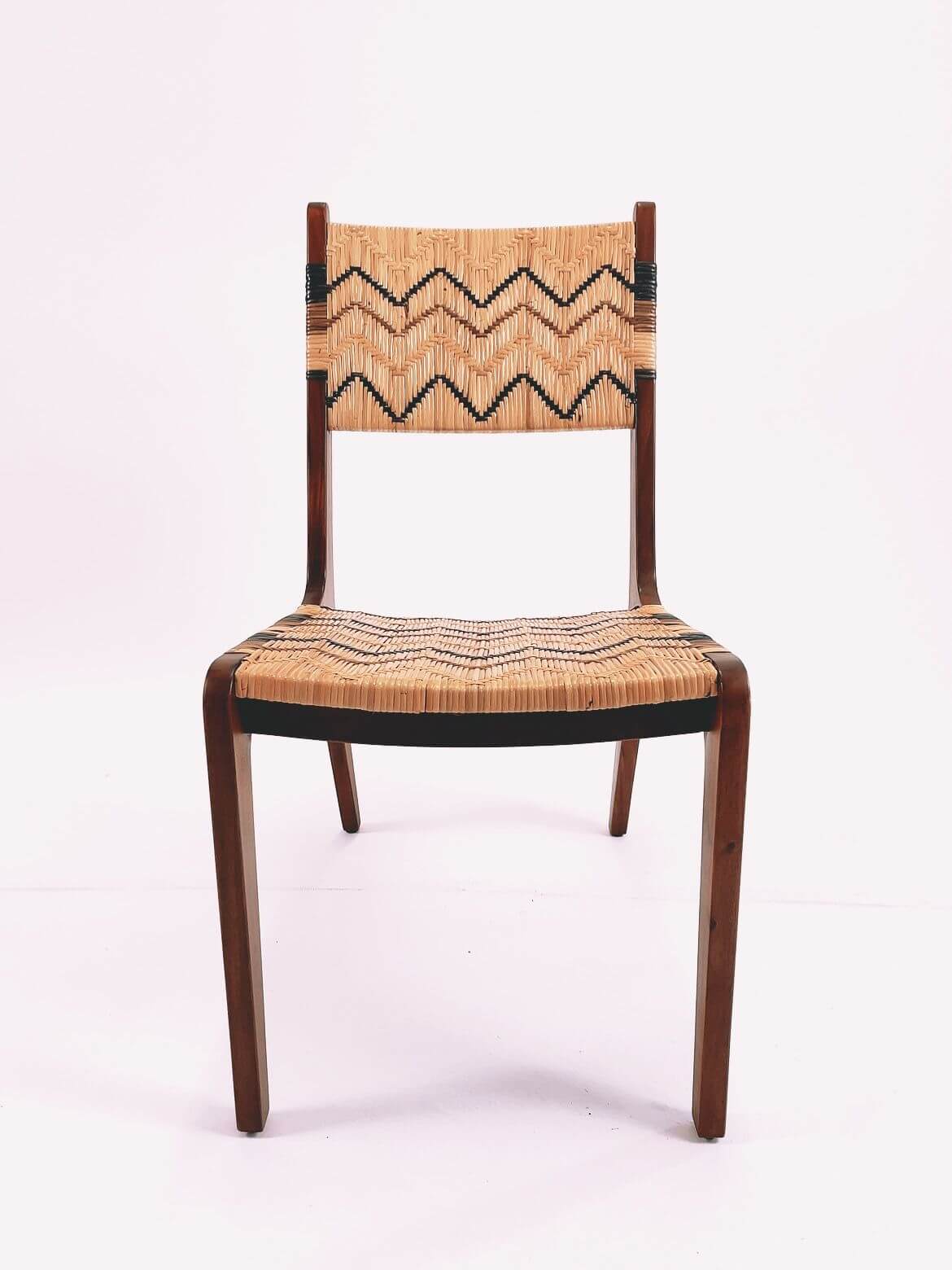 A Designer Dining Chair (Clearance) made of wood with a woven rattan seat and backrest showcasing zigzag patterns, viewed from the front.