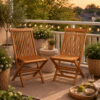 A Twisted Papasan Chair (Clearance) is set on a balcony with string lights, potted plants, and a tray holding wine glasses and fruit on a rug at sunset.