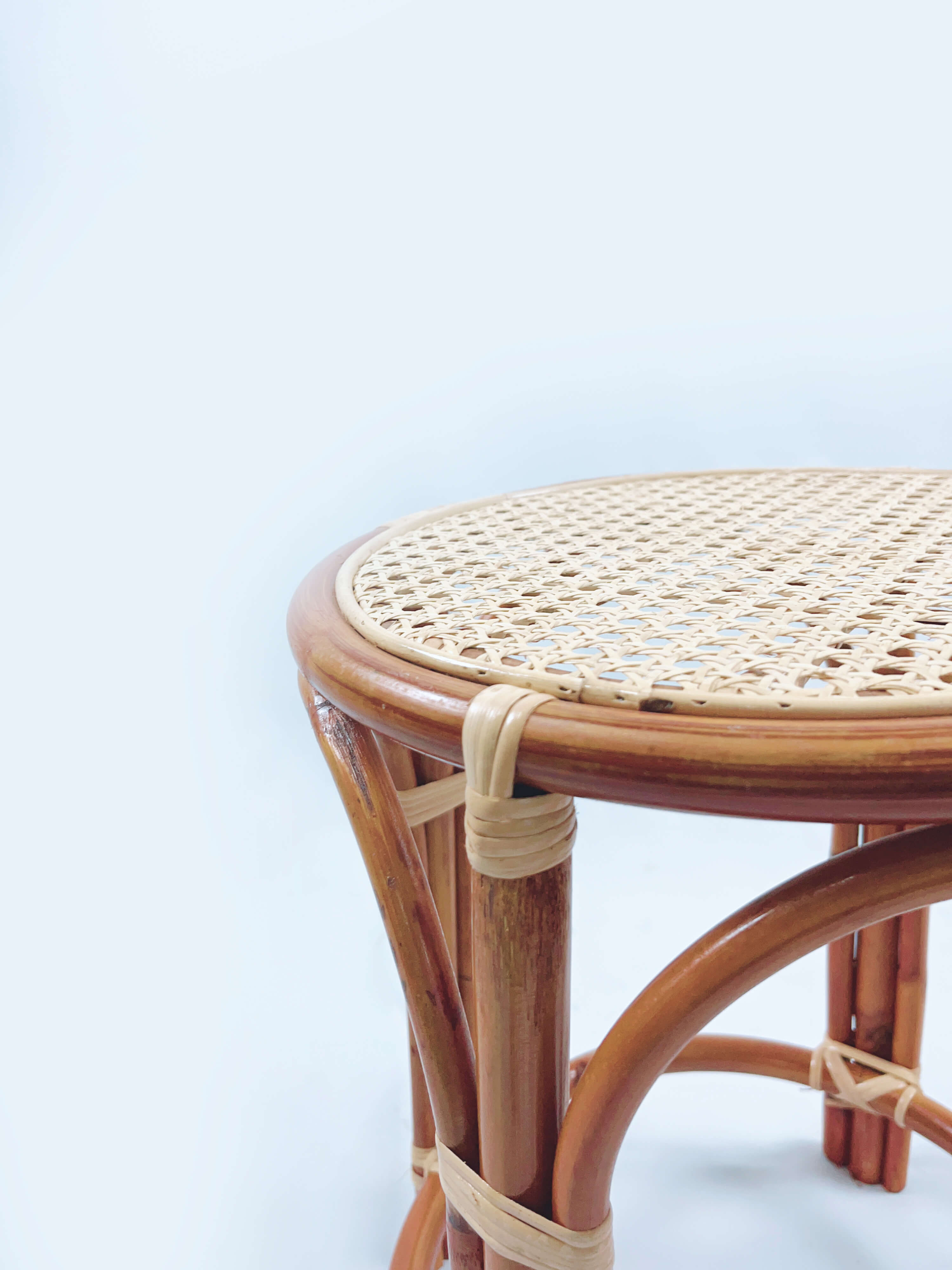 Close-up of the RC Bar Stool (No Backframe), featuring a round wicker seat made of woven rattan and supported by a wooden frame, set against a plain white background.