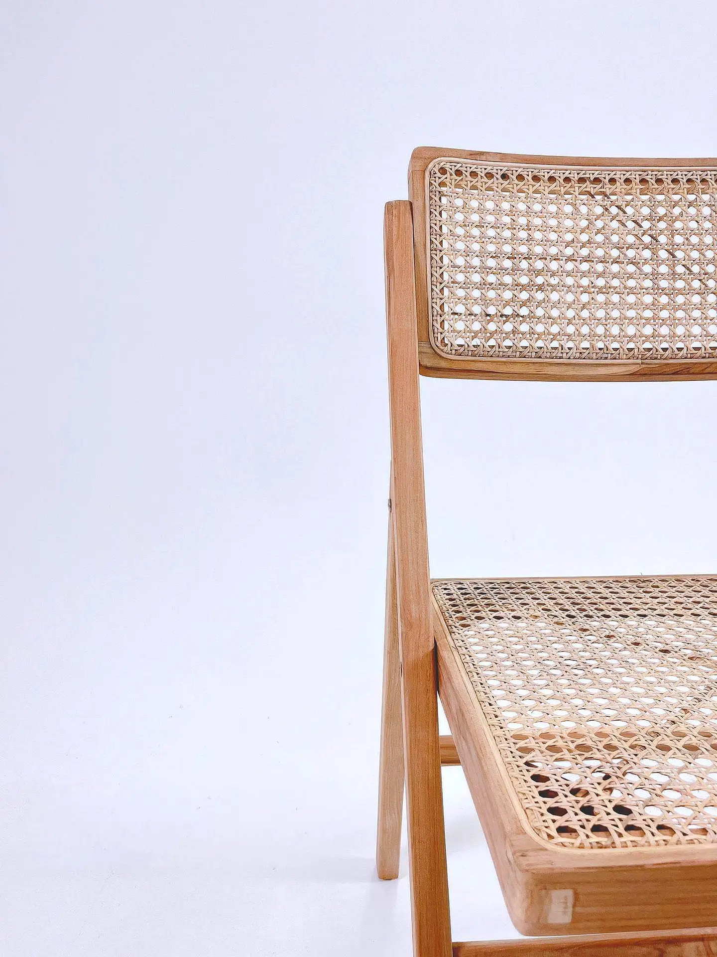 A wooden chair with a woven cane backrest and seat is positioned against a plain white background.