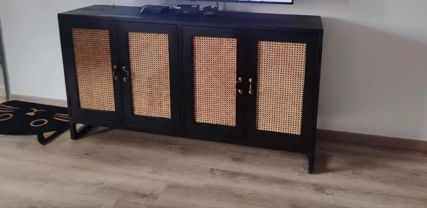 A Pacific Rattan Cabinet with four cabinet doors featuring woven rattan panels, standing on wooden flooring.