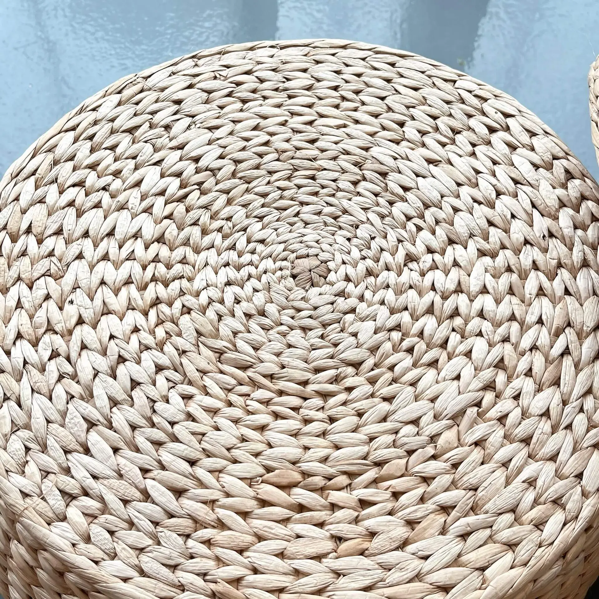 Close-up of the Seagrass Ottoman lid displaying intricate, tightly woven patterns in natural light brown hues.
