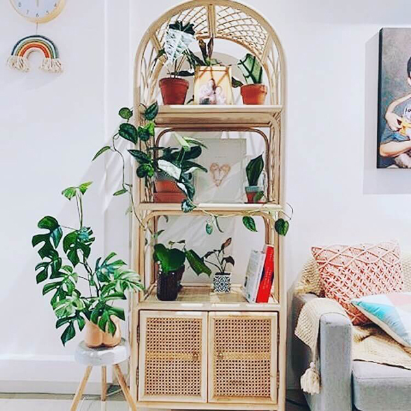 A Bookshelf With Cabinet, adorned with potted plants, books, framed photos, and decor, stands next to a light gray sofa in a bright modern living room. A Bookshelf With Cabinet, adorned with potted plants, books, framed photos, and decor, stands next to a light gray sofa in a bright modern living room.