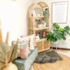 A cozy corner features a green bench with colorful pillows, a Bookshelf With Cabinet holding plants and books, a framed print on the wall, and decorative baskets on a circular rug. A cozy corner features a green bench with colorful pillows, a Bookshelf With Cabinet holding plants and books, a framed print on the wall, and decorative baskets on a circular rug.