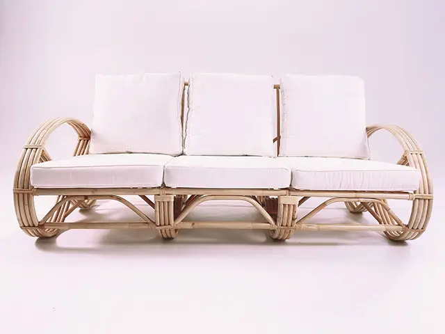 The Greeks Infinity 3 Seater Rattan Sofa features a light rattan frame with white cushions, elegantly displayed against a plain white background.
