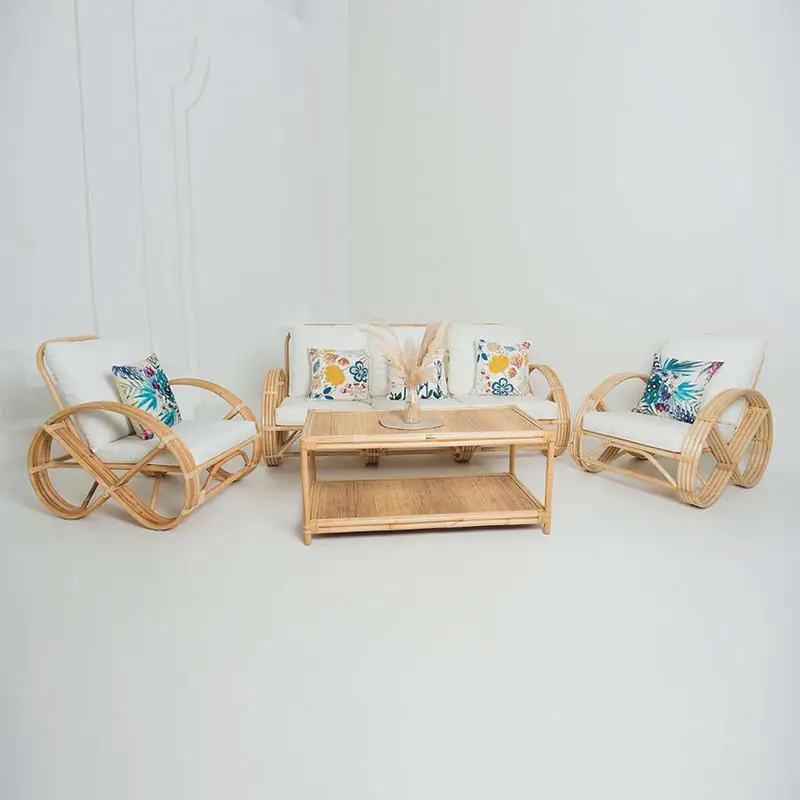 Experience the elegance of the Greeks Infinity 3 Seater Rattan Sofa set, complete with two plush chairs and a wooden coffee table adorned with a vase of dried leaves. The ensemble is beautifully accented with floral and geometric-patterned cushions, creating a charming focal point in a pristine white room.