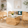 Bright living room with rattan furniture, a glass-top coffee table, decorative pillows, houseplants, and neutral decor on a natural fiber rug. Sunlight streams in from a large window.